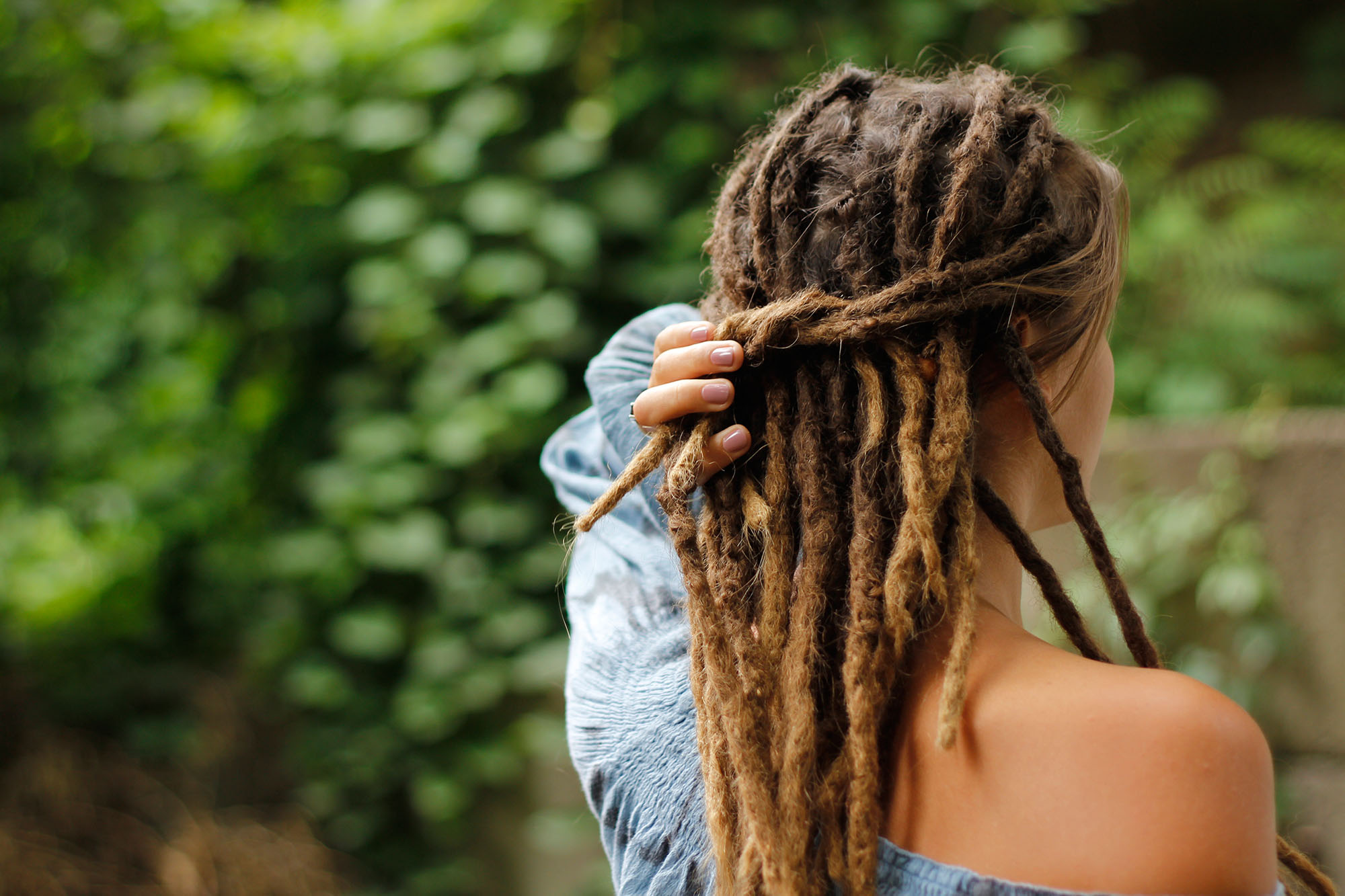White guy with blond hair dreaded. Shaved sides of head with dreadlocks on the top